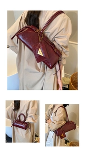 Gros plan sur le sac baguette bordeaux brillant à texture plissée et mini pochette