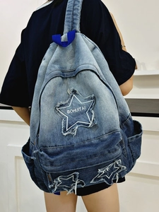 Gradient denim backpack for women with star patches and adjustable straps worn by model