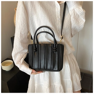 Détail du sac seau noir plissé avec anses et mousquetons en métal doré chic