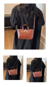 Detail of vintage brown leather handbag with round handles and adjustable shoulder strap