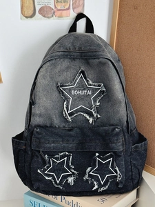 Black washed denim backpack with star patches and fringe detail for students
