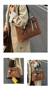 Détail d'un sac cabas en daim marron avec un ruban à carreaux et des finitions métal