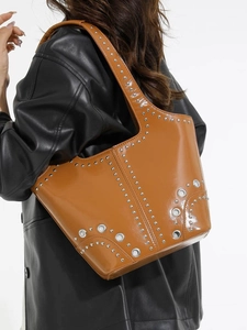 Sac seau marron en similicuir brillant avec des clous argentés et détails œillets