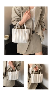 Détail du sac à main plissé blanc avec boutons décoratifs et poignées circulaires