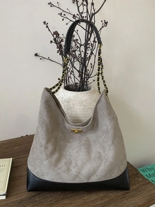Chic quilted hobo bag in taupe suede and black trim with gold chain and turn-lock detail