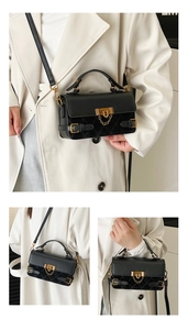 Detail view of a vintage black quilted crossbody bag with gold hardware and chain lock