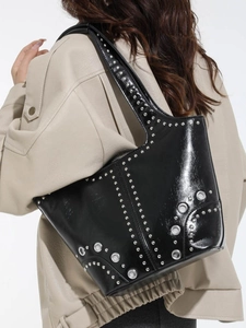 Sac fourre-tout noir à rivets avec clous argentés porté par un mannequin en veste en cuir