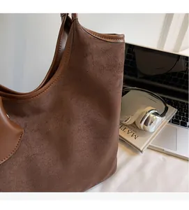 Vista dettagliata di una borsa tote in pelle scamosciata marrone con finiture