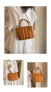 Détail du sac seau en cuir caramel avec plis verticaux et poignée supérieure ronde