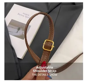 Detail of adjustable brown leather strap with golden buckle for shoulder bag