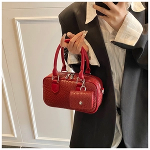 Détail d'un sac à main rouge tressé avec mini porte-monnaie assorti et boucles argentées