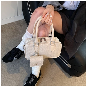 Détail du sac à main beige gaufré avec fini cuir texturé et fermeture éclair argent