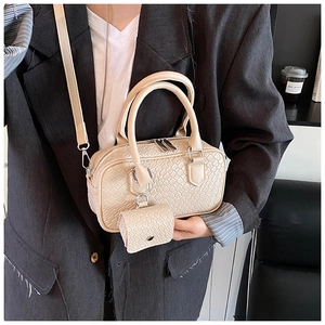 Detail of woven texture Boston bag in cream with adjustable strap and mini pouch