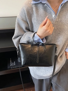 Retro black oil wax leather tote bag worn by model with adjustable shoulder strap