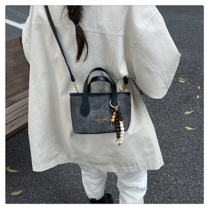 Detail of dark gray mini crossbody bag with vintage wooden beads and shoulder strap