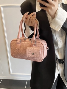 Sac à bandoulière rose à texture tissée avec mini pochette, porté par un mannequin chic