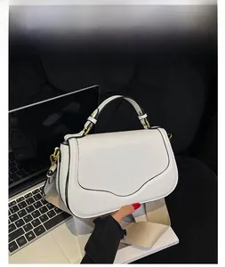 Détail du sac selle blanc en cuir PU avec boucle en métal et bandoulière tissée large