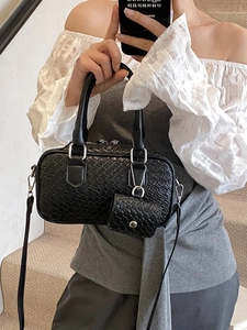 Sac bandoulière noir à texture tissée avec mini porte-monnaie porté par un mannequin