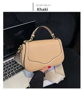 Détail du sac besace kaki avec bandoulière tissée et finitions dorées dorés