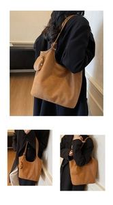 Dettaglio di una borsa tote in pelle scamosciata marrone con tracolla a nodo e mini pochette