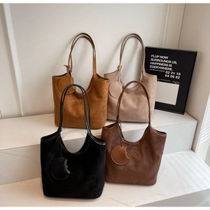Dettaglio di quattro borse tote in camoscio in vari colori con finiture in pelle