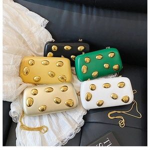 Dettaglio di pochette colorate con accenti metallici dorati e tracolla a catena sottile