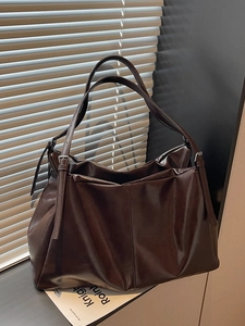 Vintage large capacity dark brown leather tote bag with silver buckles in sunlight