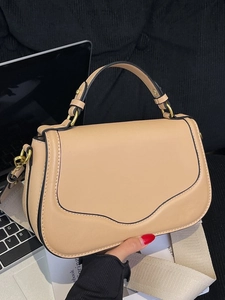 Sac selle minimaliste en cuir beige avec large bandoulière en tissu et boucles d'or