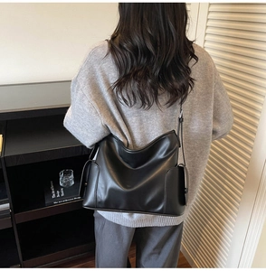 Detail view of the side pocket on a black hobo shoulder bag with a soft leather finish