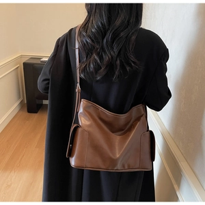 Détail du sac cabas en cuir mat marron avec poches latérales à rabat magnétique