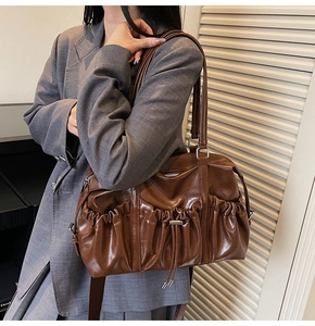 Detail of dark brown vintage bowling bag showing pleated pockets and silver drawstring buckle