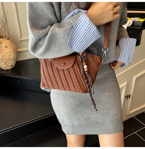 Detail of a brown woven texture crossbody bag with wooden bead ethnic charms