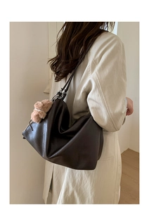 Large dark brown soft leather tote bag with a cute plush bear charm on model's shoulder
