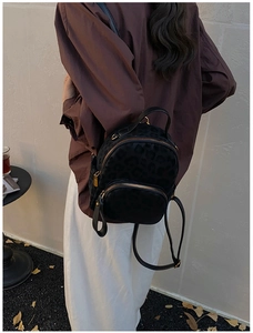 Rückansicht eines Modells mit schwarzem Mini-Rucksack mit Leopardenmuster und Goldzipper