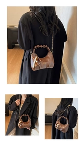 Detail of dark brown pleated handbag with bohemian wood bead charm and chain strap