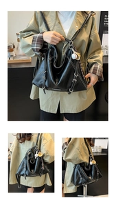 Close-up of black PU leather bag showing white contrast stitching and silver buckle detail