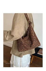 Dettaglio della borsa tote leopardata con tracolla annodata indossata da una modella