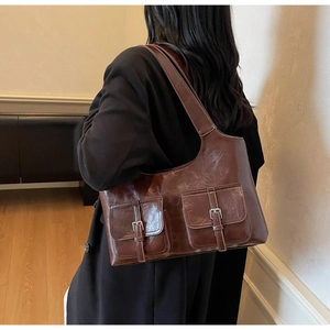 Deep brown faux leather shoulder bag with vintage dual pockets worn by a model
