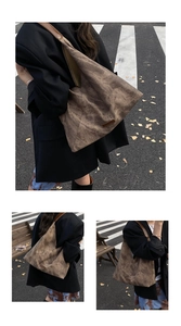 Close-up of vintage brown suede tote bag with logo patch and long leather strap in street