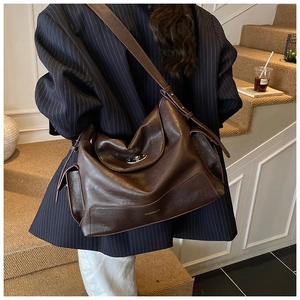 Detail of dark brown leather tote bag with silver twist lock and smooth texture