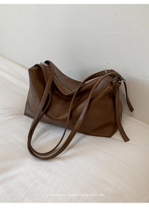 Detail view of large retro dark brown leather tote bag with soft texture and straps