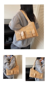 Macro shot of khaki PU leather shoulder bag with dual front pockets and metal buckles