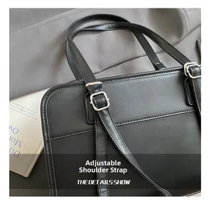 Detail shot of the adjustable silver buckle and black matte leather strap on a shoulder bag