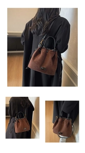 Detail of brown faux suede bucket bag with drawstring closure and brand logo