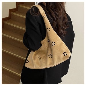 Detail of laser-cut flower pattern on light brown suede tote bag for women
