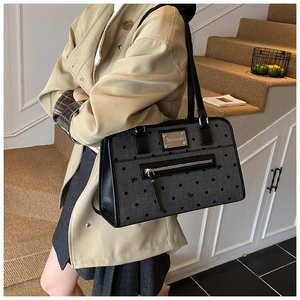 Detail of grey polka dot canvas tote with black leather trim and silver metal logo