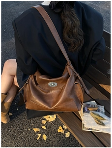 Detail of brown oil wax leather tote bag with silver metal twist lock in autumn setting