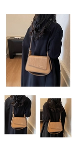Detail of camel leather crossbody bag featuring woven texture and adjustable wide strap