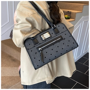 Polka dot denim shoulder bag with bow embroidery shown on a model for size scale