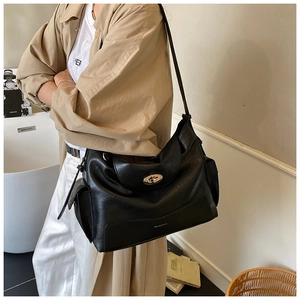 Detailed view of large black tote bag featuring a silver oval twist-lock closure